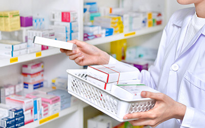 A pharmacist places medicine in stock. Quality assurance in pharma industry is critical.