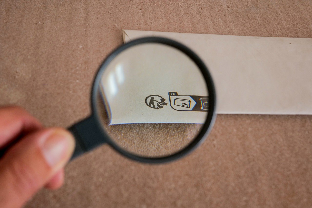 A magnifying glass hovers over a piece of white paper as a symbol for our inspection software